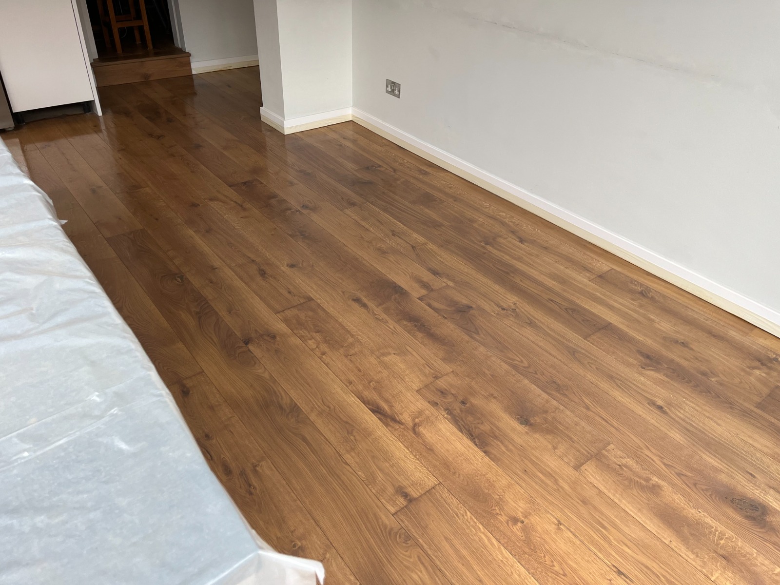 Freshly refinished oak plank hardwood floor after Professional Wood Floor Sanding, displaying rich honey-brown tones and a smooth satin sheen.