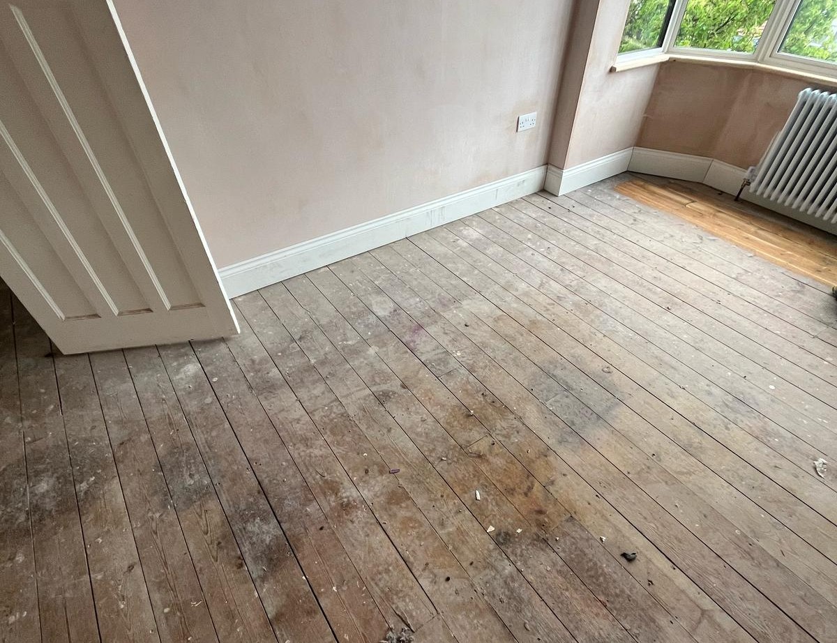 Dusty, worn solid pine floorboards awaiting Wood Floor Sanding to restore their natural colour and smoothness.