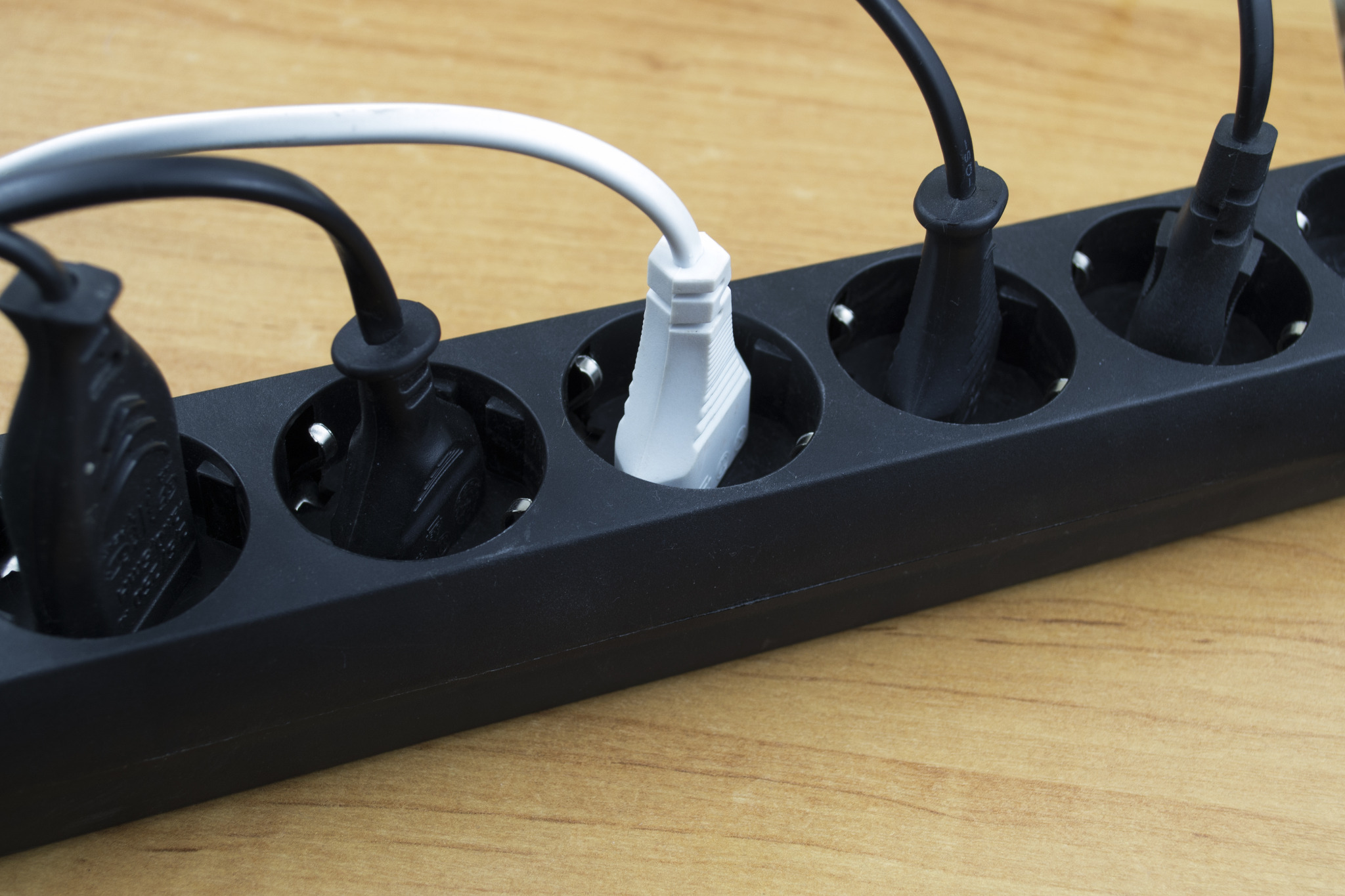 Floor Sanding Preparation Checklist reminder with overloaded extension lead on an oak plank wood floor, showing multiple plugs in one socket strip.