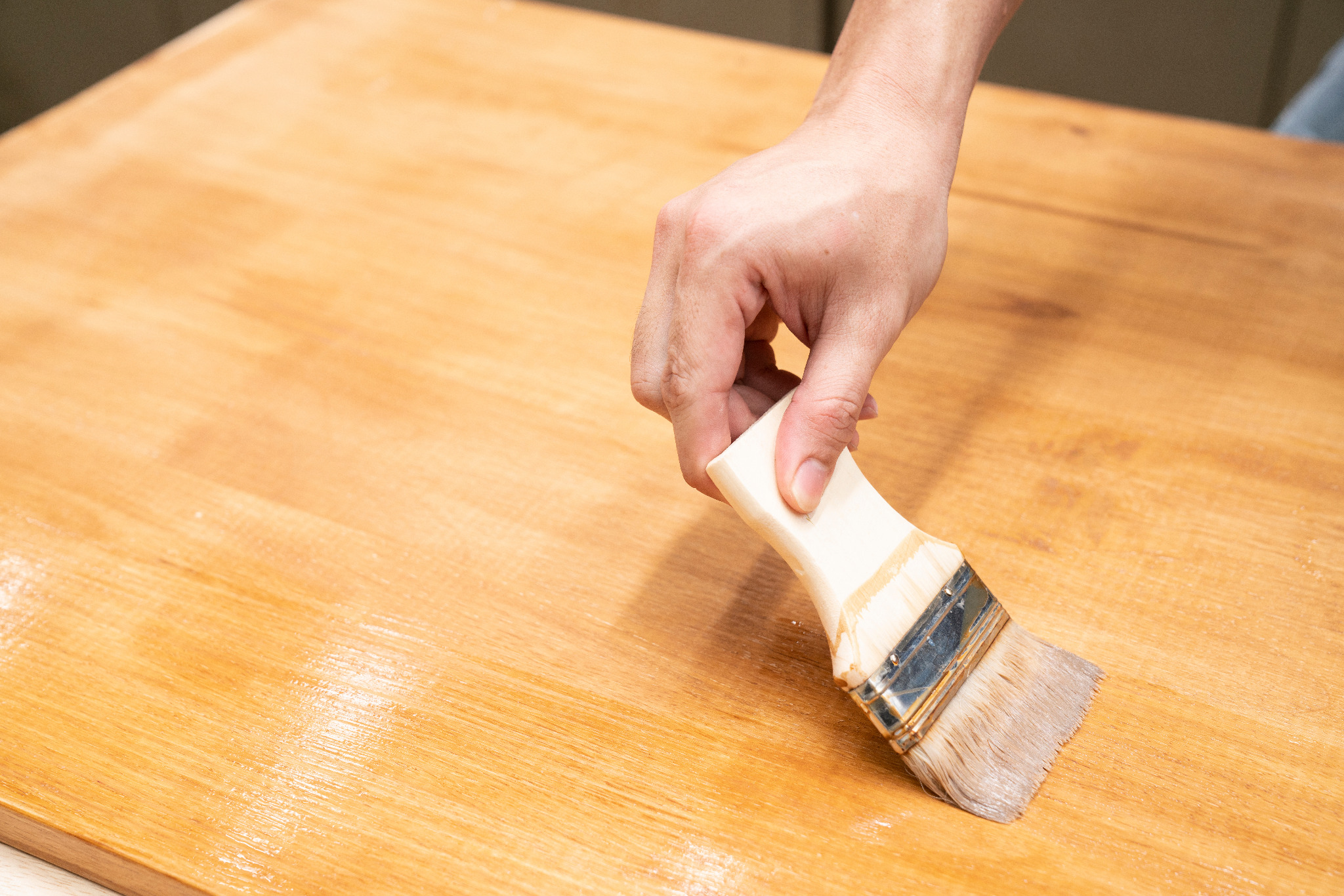 Worktop Refinishing on a solid oak hardwood kitchen worktop – close-up of a hand brushing protective finish onto the sanded oak surface for a smooth, showroom-quality result.