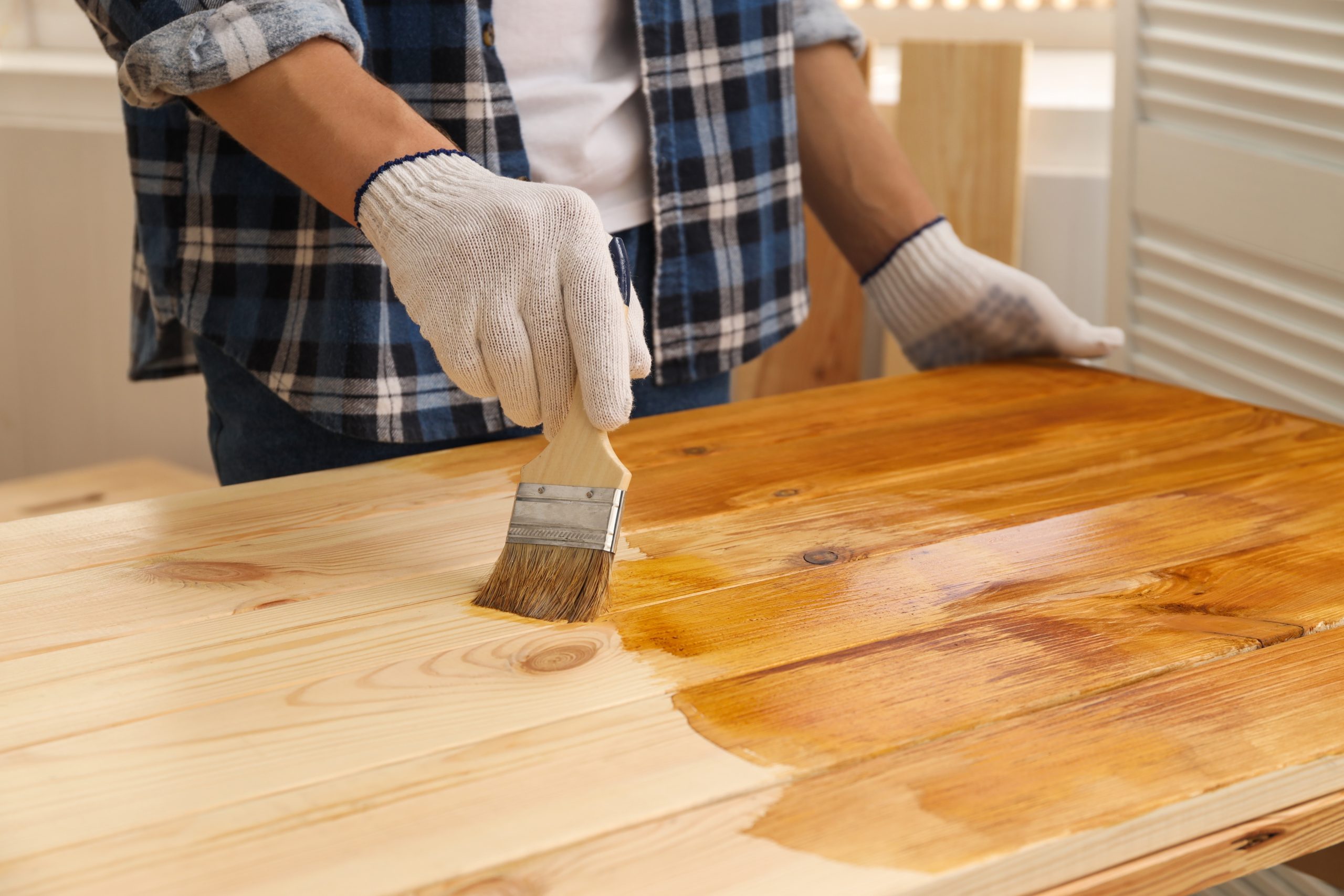 Worktop Refinishing on a solid pine wood worktop, with a professional applying fresh finish that matches the look of a solid pine wood floor.