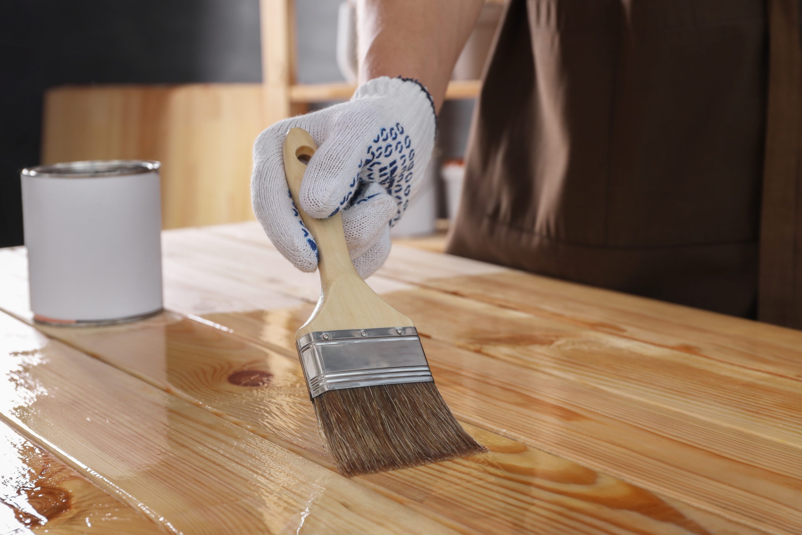 Worktop Refinishing on a solid pine wood worktop and matching solid pine wood floor, with a professional applying clear finish using a wide brush.