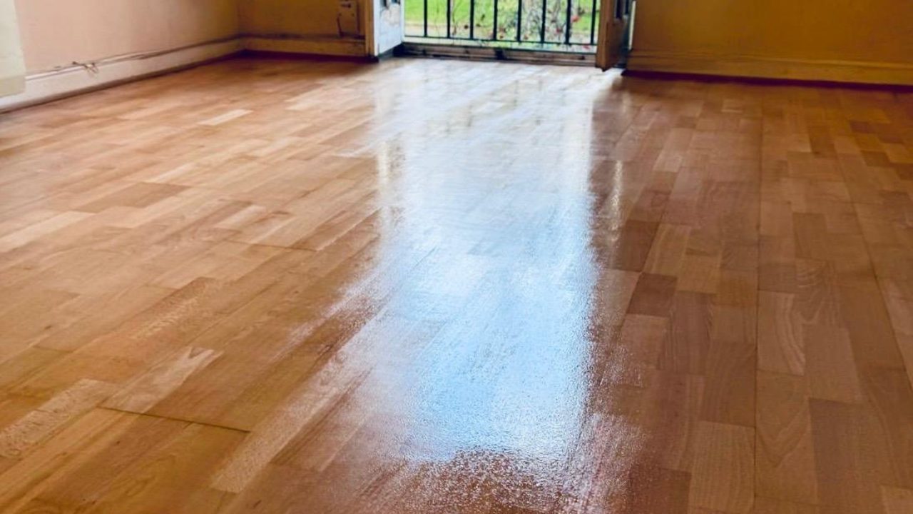 Hardwood Floor Refinishing result showing a freshly sealed beech block hardwood floor with a smooth, glossy sheen and rich colour across a living room.