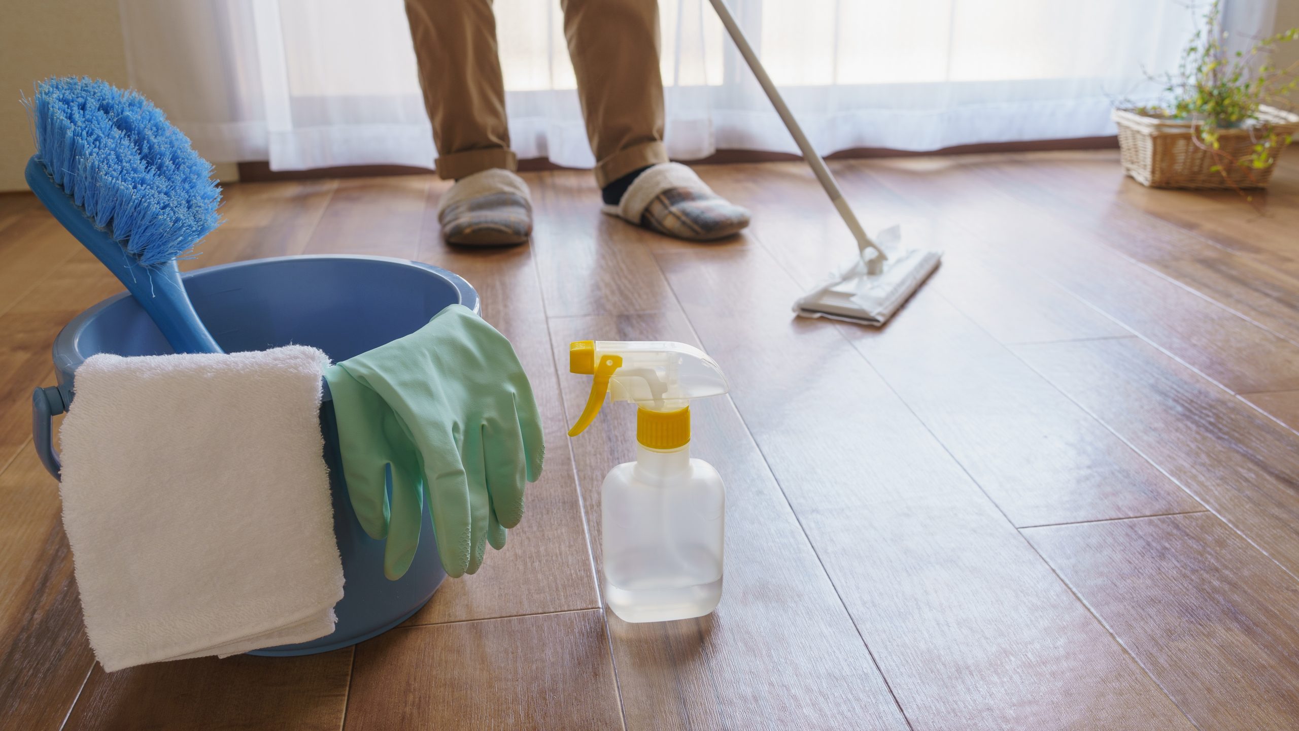 Hardwood Floor Refinishing setup showing a roller, paint tray and sealant ready to apply a protective coat to a light oak block hardwood floor for a smooth, luxury finish.